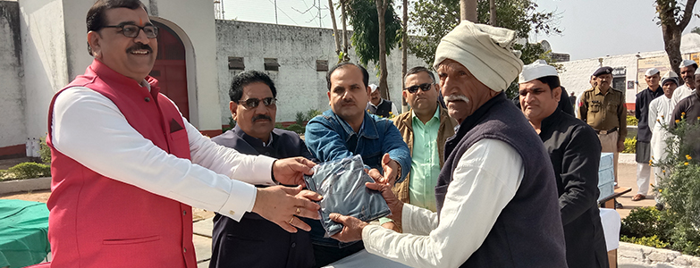 Community program distributing clothes to needy individuals with officials and villagers participating