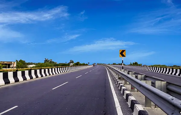 Indian national highway road with divider, railings, and clear blue sky