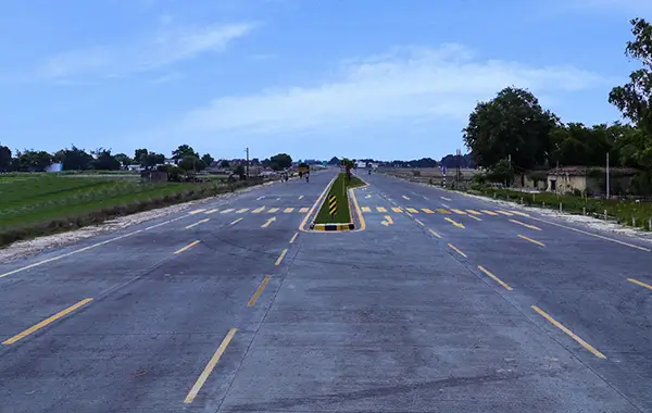 Wide concrete highway with yellow lane markings and central divider