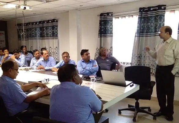 Employees attending an indoor training session at Prism Johnson while a trainer delivers a presentation