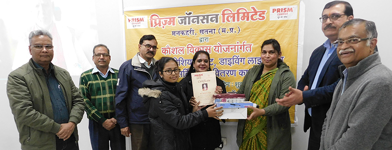 Prism Johnson Limited team distributing certificates and sewing kits to women during a skill development program
