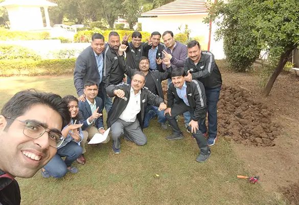 Prism Johnson employees participating in an outdoor team-building activity and posing for a group photo