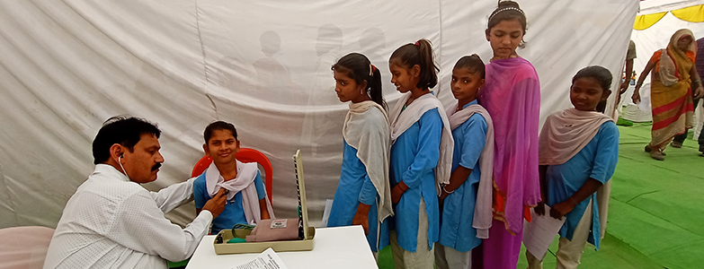 Doctor conducting health checkup for school girls during a medical camp organized by Prism Cement 01