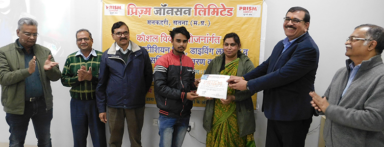 Skill development training program participants receiving certificate at Prism Johnson event