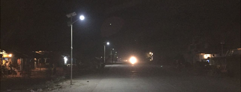 Solar-powered street lights illuminating rural road at night promoting sustainable energy and infrastructure development