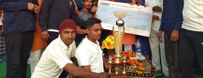 Winners posing with trophy and cheque during rural sports event award ceremony